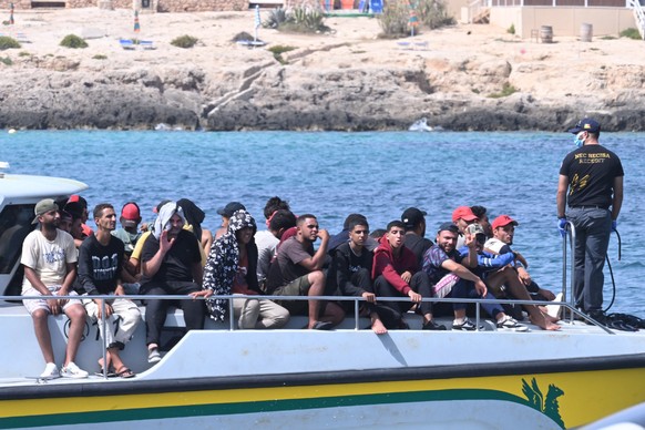 epa10869372 77 migrants from Egypt, Bengal, Syria, Ethiopia, and Sudan arrive from Tunsia in Lampedusa after their two boats were rescued by the Guardia di Finanza V827 patrol boat, 19 September 2023, ...