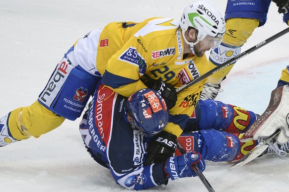 Der Davoser Beat Forster, rechts, drueckt den Zuercher Chris Baltisberger, links aufs Eis im Playoff-Finalspiel der National League A zwischen den ZSC Lions und dem HC Davos am Samstag, 11. April 2015 ...