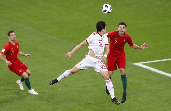 Iran&#039;s Sardar Azmoun, center, jumps for the ball with Portugal&#039;s Pepe, right, as Portugal&#039;s Cedric looks them during the group B match between Iran and Portugal at the 2018 soccer World ...