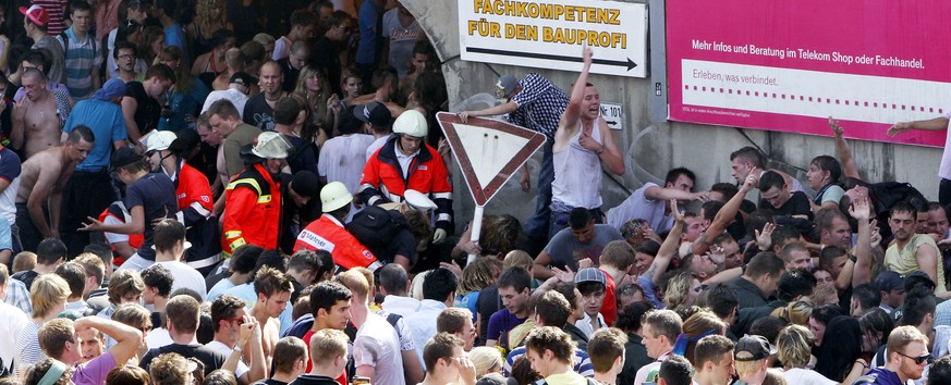 Teilnehmer versuchen am Samstag, 24. Juli 2010, in Duisburg, Nordrhein-Westfalen, beim Techno-Musikfestival Loveparade 2010 nach einer Panik das gesperrte Gelaende zu verlassen. Vor dem Gelaende vor d ...