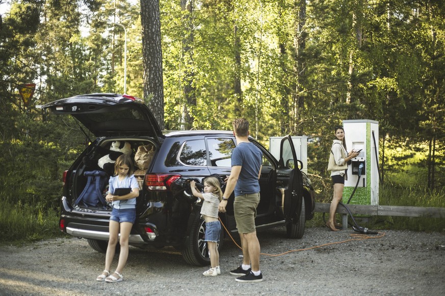 Familie lädt gerade ihr E-Auto