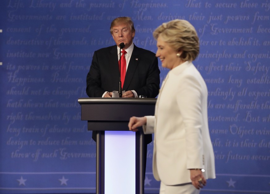 Republican presidential nominee Donald Trump waits behind his podium as Democratic presidential nominee Hillary Clinton makes her way off the stage following the third presidential debate at UNLV in L ...