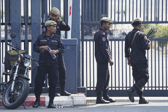 Cambodian police officers stand guard as they wait for 18 soldiers released after being captured and held by the Thai army, at former Phnom Penh International Airport in Phnom Penh, Cambodia, Wednesda ...