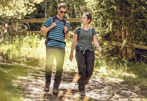 A couple walks through a forest in the national park