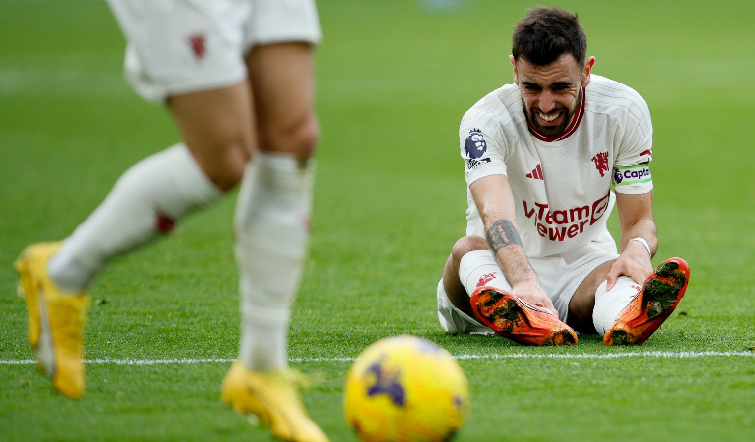 epa11041916 Bruno Fernandes of Manchester United holds an injured ankle during the English Premier League soccer match between West Ham United and Manchester United, in London, Britain, 23 December 20 ...