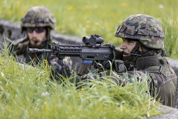 A parascout recruit in a trench holds a SG 550 assault rifle in his hands, pictured on June 17, 2013, in the recruit school for parascouts of the Swiss army in Altmatt, canton of Schwyz, Switzerland.  ...