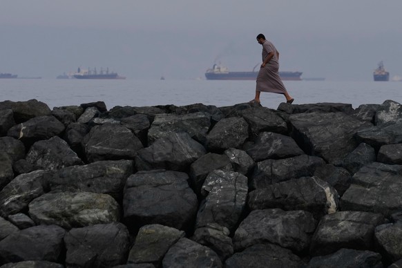 A man walks along the shore as oil tankers and cargo ships line up in the Strait of Hormuz, seen from Khor Fakkan, United Arab Emirates, Wednesday, March 11, 2026. (AP Photo/Altaf Qadri)
AP-Pictures-o ...