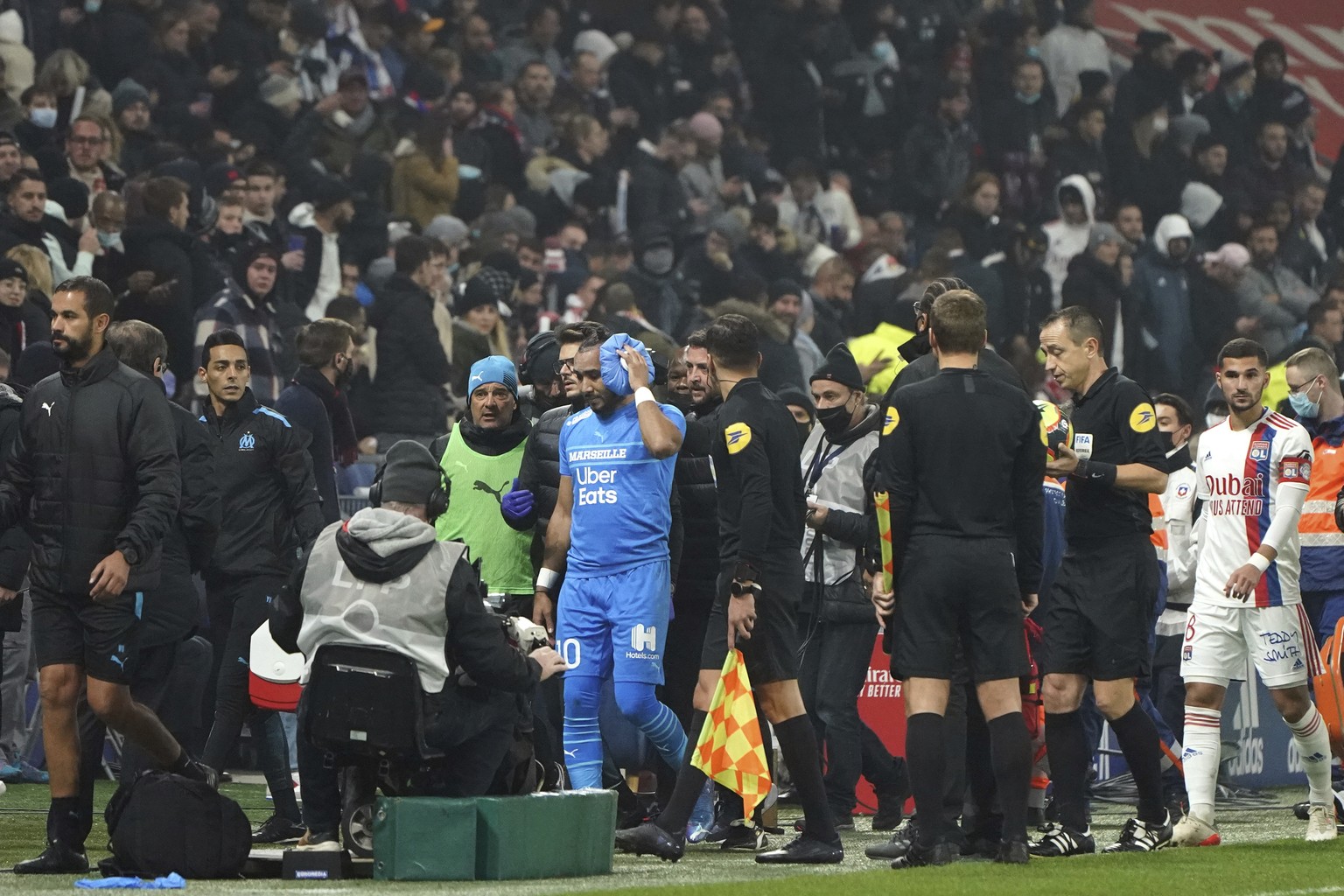 Marseille&#039;s Dimitri Payet, center, is surrounded by his staff as he leaves the field after being injured by an object thrown by a Lyon&#039;s supporter during the French League One soccer match b ...