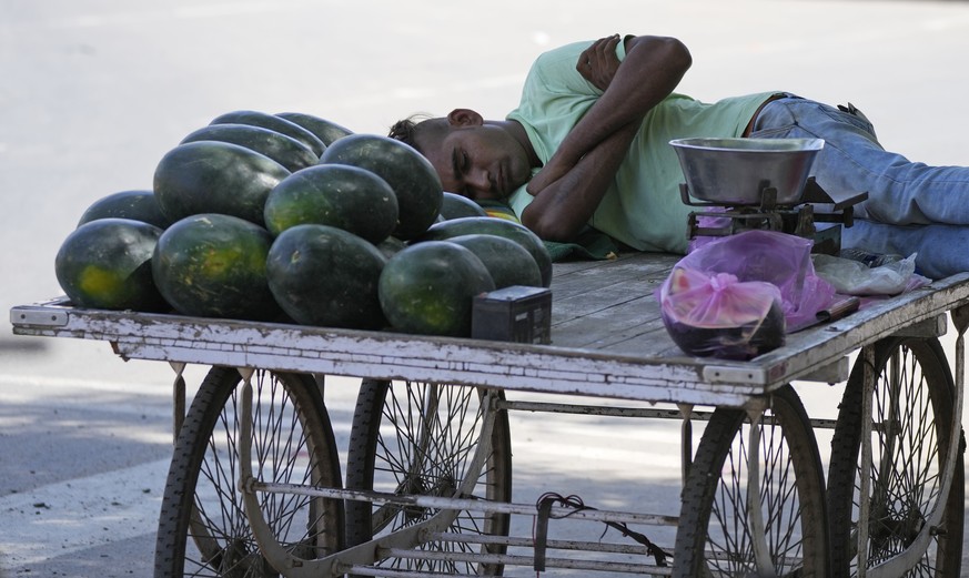 A man selling watermelons rests in the shade of a tree on a hot day in Ahmedabad, India, Thursday, April 28, 2022. (AP Photo/Ajit Solanki)