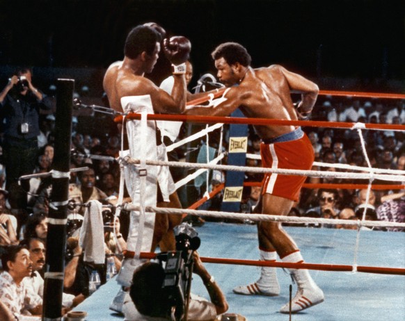 Blick auf eine Szene des Weltmeisterschaftskampfes am 30. Oktober 1974 in Kinshasa (Zaire); George Foreman (rechts) schlaegt seine Linke auf Muhammad Ali. Ali holt sich mit einem sensationellen K.O.-S ...