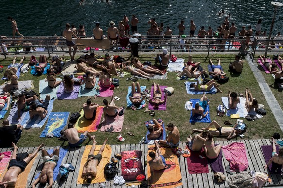 Menschen sonnen sich an der Limmat, aufgenommen am Pfingst-Montag, 9. Juni 2014 am Letten in Zuerich. Das hochsommerliche Wetter am Pfingstwochenende hat den Schweizer Freibaedern einen Besucheranstur ...