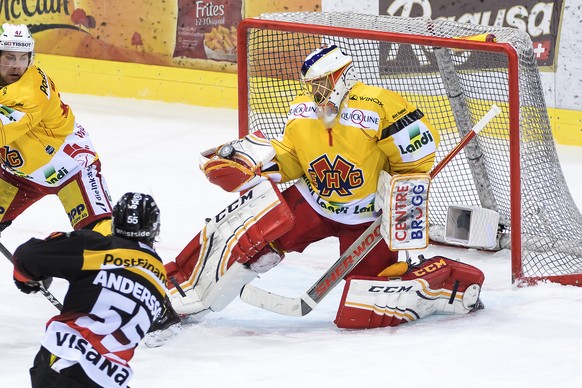 Biels Goalie Jonas Hiller, rechts, stoppt ein schiesst von Berns Calle Andersson, links, im fuenften Eishockey Playoff-Halbfinalspiel der National League zwischen dem SC Bern und dem EHC Biel, am Donn ...