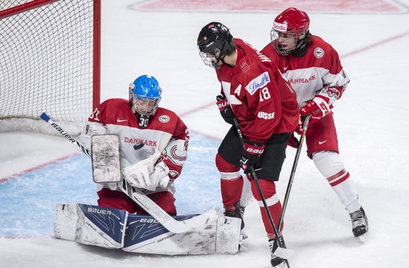 Denmark goaltender Lasse Petersen stops the puck in front of Switzerland&#039;s Nico Hischier and Denark&#039;s Oliver Larsen during the first period of a World Junior hockey tournament game Friday, D ...
