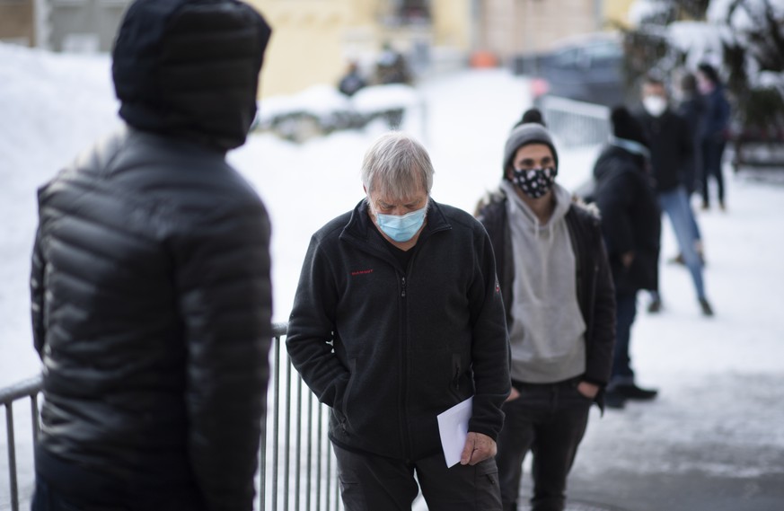 Menschen stehen an bei Covid-19 Flaechentests, aufgenommen am Freitag, 11. Dezember 2020, in Zuoz. Der Kanton Graubuenden fuehrt derzeit in drei Regionen freiwillige Flaechentests als Pilotprojekt dur ...