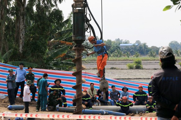 epa10386775 A handout photo made available by Vietnam News Agency shows rescuers gather at the site where a 10-year-old boy is stuck in a 35-meter deep hole in Dong Thap Province, Vietnam, 02 January  ...