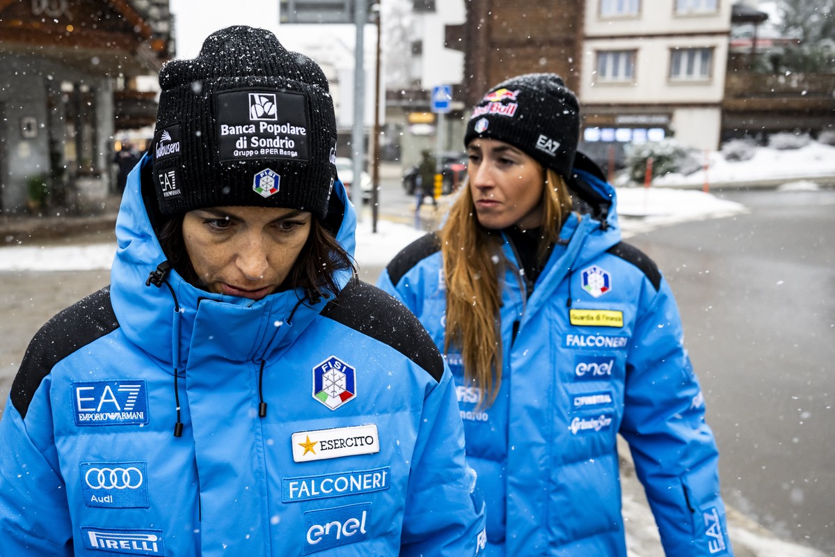 epa12687666 The Italian women ski team members Elena Curtoni (L) and Sofia Goggia react after they paid tribute to the victims in front of the entrance of the 'Le Constellation' bar after th ...