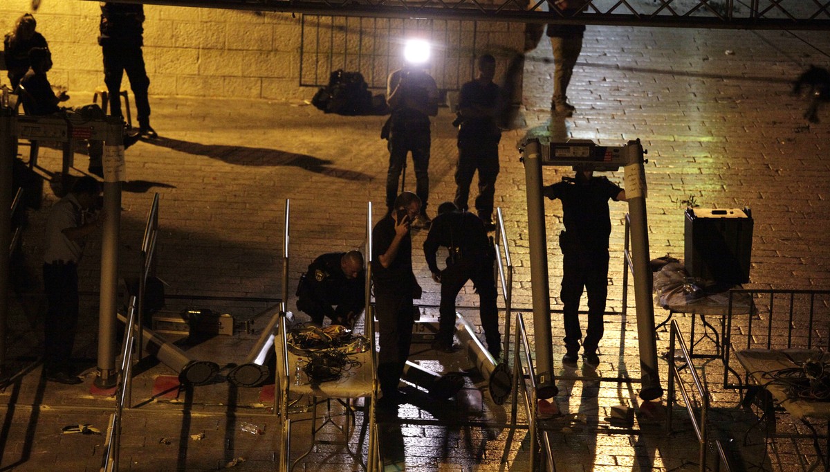 Israeli police officers dismantle metal detectors outside the Al Aqsa Mosque compound in Jerusalem's Old City, early Tuesday, July 25, 2017. Israel's security cabinet has decided to remove m ...