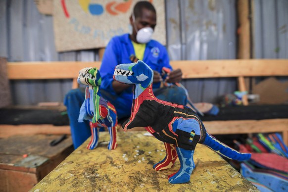epa10228963 A Kenyan worker from the social enterprise &#039;Ocean sole&#039; glues together old flip-flops as preparation for assembling them at their workshop in Nairobi, Kenya, 06 October 2022 (iss ...