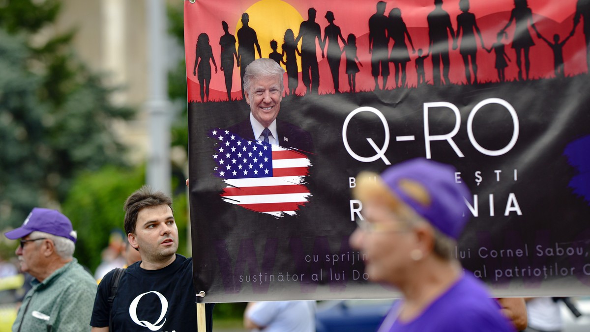 Romanian supporters of QAnon take part in a rally against the government's measures to prevent the spread of COVID-19 infections, like wearing a face mask, in Bucharest, Romania, Monday, Aug. 10, ...