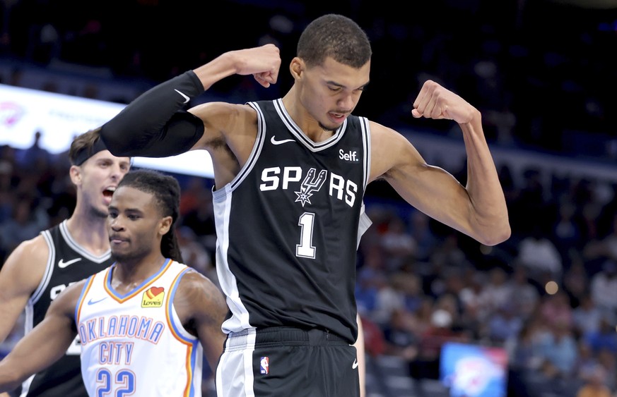 San Antonio Spurs center Victor Wembanyama (1) celebrates after a basket in front of Oklahoma City Thunder guard Cason Wallace (22) in the first half of a preseason NBA basketball game, Monday, Oct. 9 ...