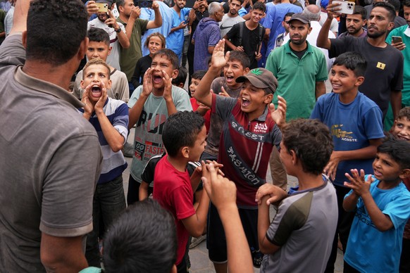 Palestinians celebrate following the announcement that Israel and Hamas have agreed to the first phase of a peace plan to pause the fighting, outside Al-Aqsa Hospital in Deir al-Balah, central Gaza St ...
