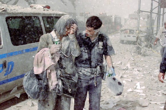Police officer Mike Brennan helps a distraught woman known o
UNITED STATES - SEPTEMBER 11: Police officer Mike Brennan helps a distraught woman known only as Beverly, as ash and debris cover the area  ...