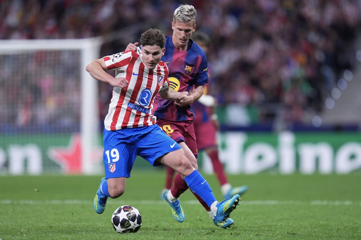 Atletico Madrid's Julian Alvarez, front, and Barcelona's Dani Olmo challenge for the ball during the Champions League quarterfinal second leg soccer match between Atletico Madrid and Barcelo ...