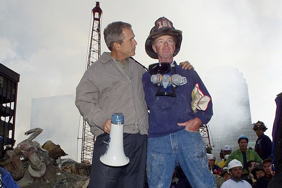 FILE ? As rescue efforts continue in the rubble of the World Trade Center in New York, President George W. Bush, left, stands with New York City firefighter Bob Beckwith on a burnt fire truck in front ...