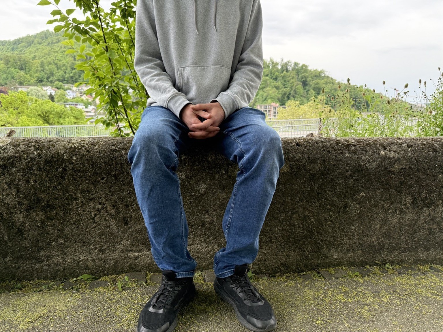 Tristan* sitzt auf einer Mauer. Reportage zu Menschen, die keine engen Freundschaften haben.