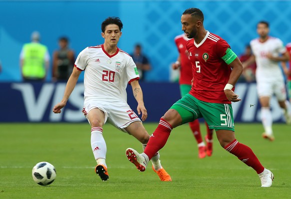 epa06810564 Mehdi Benatia of Morocco (R) and Sardar Azmoun of Iran in action during the FIFA World Cup 2018 group B preliminary round soccer match between Morocco and Iran in St.Petersburg, Russia, 15 ...