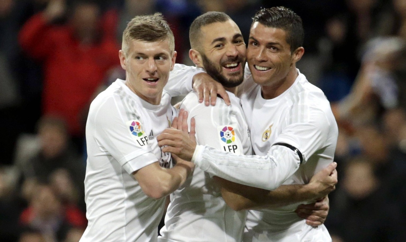 Real Madrid s French Karim Benzema (C) celebrates with Cristiano Ronaldo (R) and Toni Kroos (L) after scoring the opening goal against Sevilla CF during the Spanish Liga Primera Division soccer match  ...