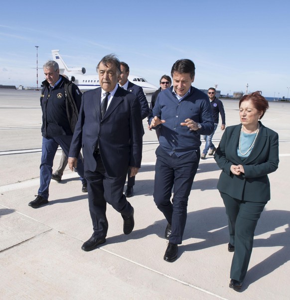 epa07140746 A handout photo made available by the Chigi Palace (Palazzo Chigi) Press Office shows Italian Premier Giuseppe Conte (C) being welcomed by Palermo Mayor Leoluca Orlando (C-L) upon his arri ...