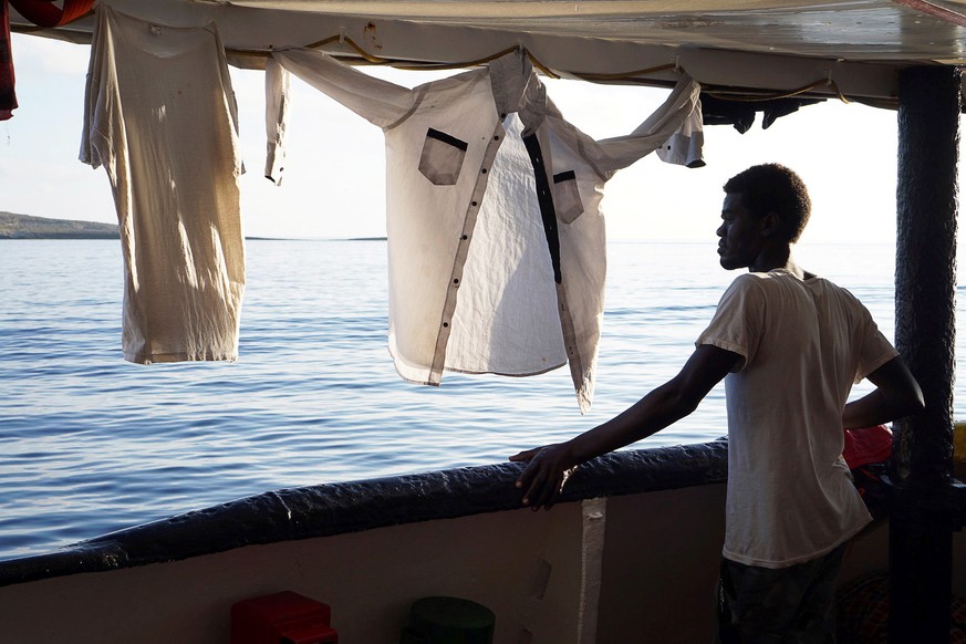 epaselect epa07778905 One of 107 migrants looks towards the Italian coast from the deck of Spanish rescue vessel Open Arms, near Lampedusa, Italy, 18 August 2019. A day after 27 minors and ill migrant ...