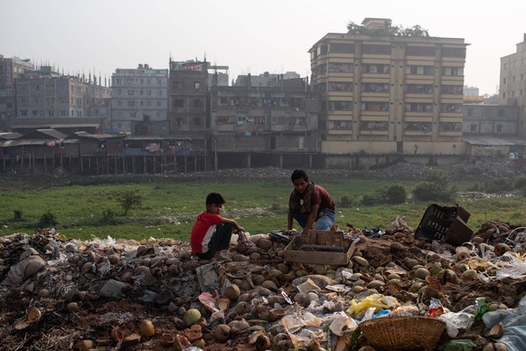Zwei Jungen durchsuchen Abfall in Dhaka, Bangladesch.