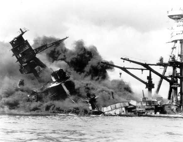 In this Dec. 7, 1941 file picture, the battleship USS Arizona belches smoke as it topples over into the sea during a Japanese surprise attack on Pearl Harbor, Hawaii. (AP Photo)