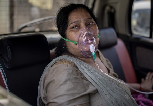 A COVID-19 patient sits inside a car and breathes with the help of oxygen provided by a Gurdwara, a Sikh house of worship, in New Delhi, India, Saturday, April 24, 2021. India