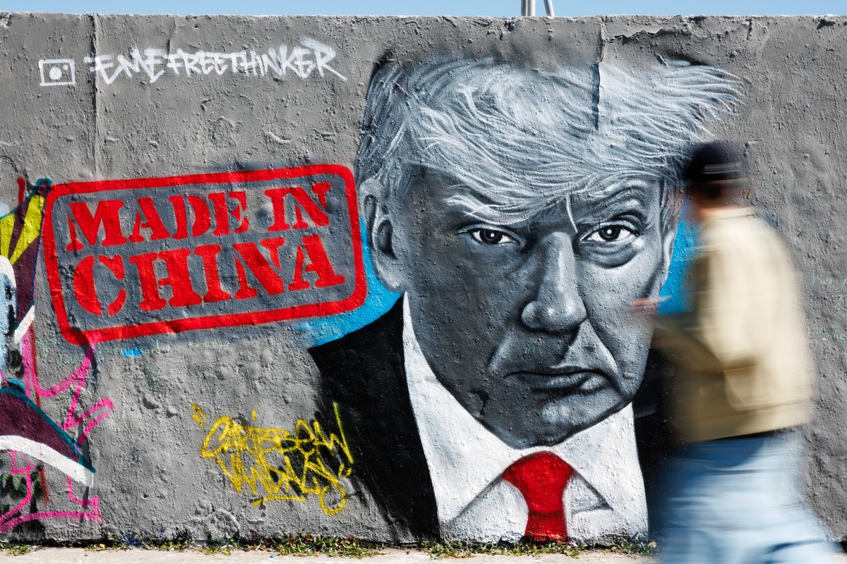 epa12060350 A passer-by walks in front of a graffito of Berlin-based artist Eme Freethinker that shows US President Donald J. Trump next to the writing 'Made in China' at the Mauerpark in Be ...