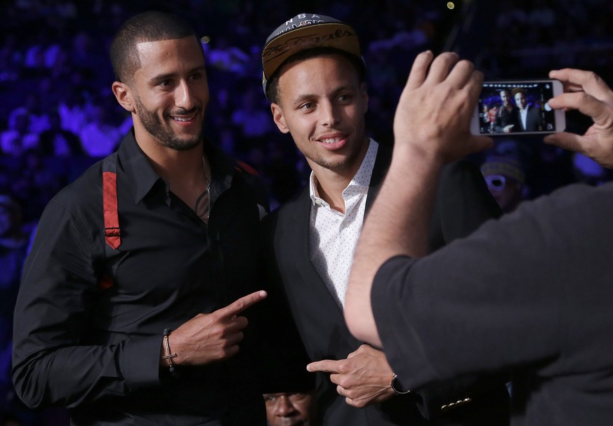 San Francisco 49ers quarterback Colin Kaepernick, left, poses for photos with Golden State Warriors guard Stephen Curry during a boxing event featuring Andre Ward against Paul Smith in a cruiserweight ...