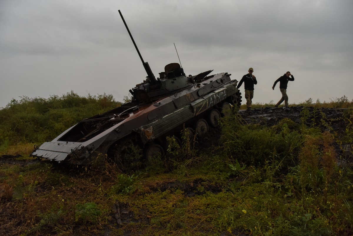 epa10186477 Ukrainian serviceman stand near a burned Russian BMP 2 APC in Kharkiv region, Ukraine, 15 September 2022. The Ukrainian army pushed Russian troops from occupied territory in the northeast  ...