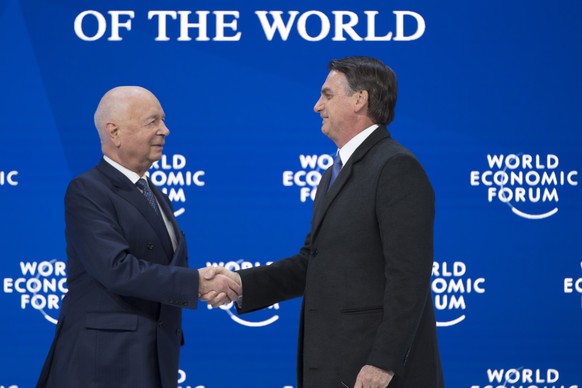 epa07309443 Brazil&#039;s President Jair Bolsonaro, (R), shakes hands with German Klaus Schwab, (L), Founder and Executive Chairman of the World Economic Forum, WEF, during a plenary session in the Co ...