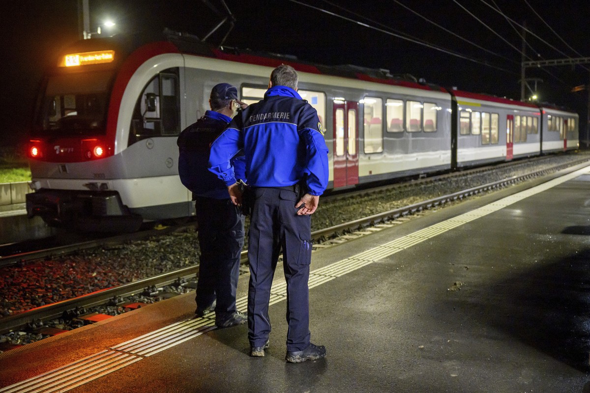 Vaud cantonal police officers watch the Travys train where a hostage-taking incident took place at Essert-sous-Champvent station, Switzerland, Thursday, Feb. 8, 2024. A hostage-taking incident took pl ...