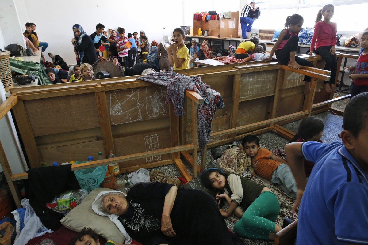 FILE - In this Saturday, July 19, 2014, file photo, Palestinians live at a United Nations school where dozens of families have sought refuge after fleeing their homes following heavy Israeli forces  ...