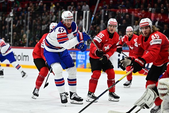 epa12135191 USA&#039;s Michael McCarron (#47) and Switzerland&#039;s Tyler Moy (#95) and Michael Fora (#45) in front of the Swiss goal during the IIHF Ice Hockey World Championship final match between ...