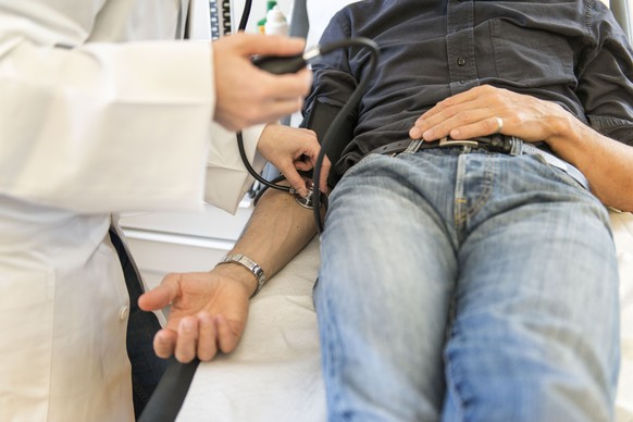 ARCHIVBILD ZUM BR-VORSCHLAG ZUR ZULASSUNGSBESCHRAENKUNG NEUER ARZTPRAXEN --- [EDITORS NOTE: POSED PICTURE] A doctor measures the blood pressure of his patient, pictured on March 28, 2014. (KEYSTONE/Ch ...