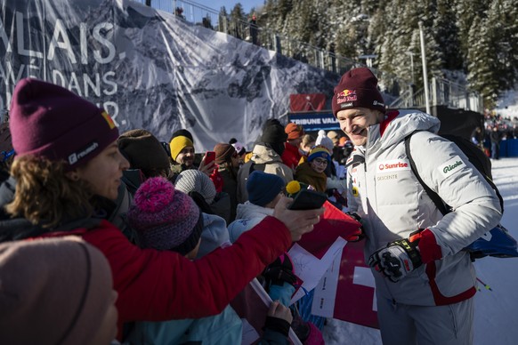 epa12694038 Marco Odermatt (R) of Switzerland takes photographs with fans in the finish area after a training session for the men's Downhill race at the Alpine Skiing FIS Ski World Cup, in Crans- ...