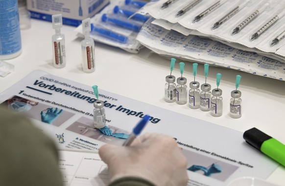 An employee of the vaccination campaign prepares Biontech doses against the COVID-19 disease in Osnabueck, Germany, Saturday, Nov. 13, 2021. Germany has struggled to bring new momentum to its vaccinat ...