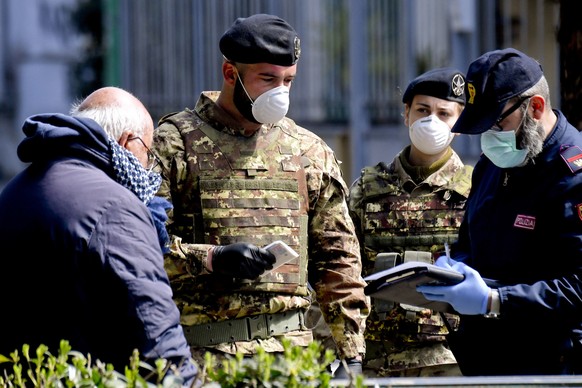 Ein älterer Passant wird in Neapel von Armee und Polizei kontrolliert.