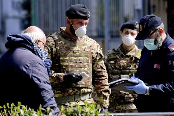 epa08315442 Italian Army soldiers and police jointly patrol the streets in a Naples neighborhood after the Italian government decided to deploy troops to check the compliance with the general lockdown ...