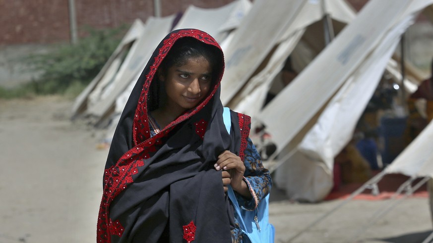 Flood victim Rajul Noor walks towards her tent school at a relief camp, in Dadu, a district of southern Sindh province, Pakistan, Sept. 23, 2022. Every part of Noor