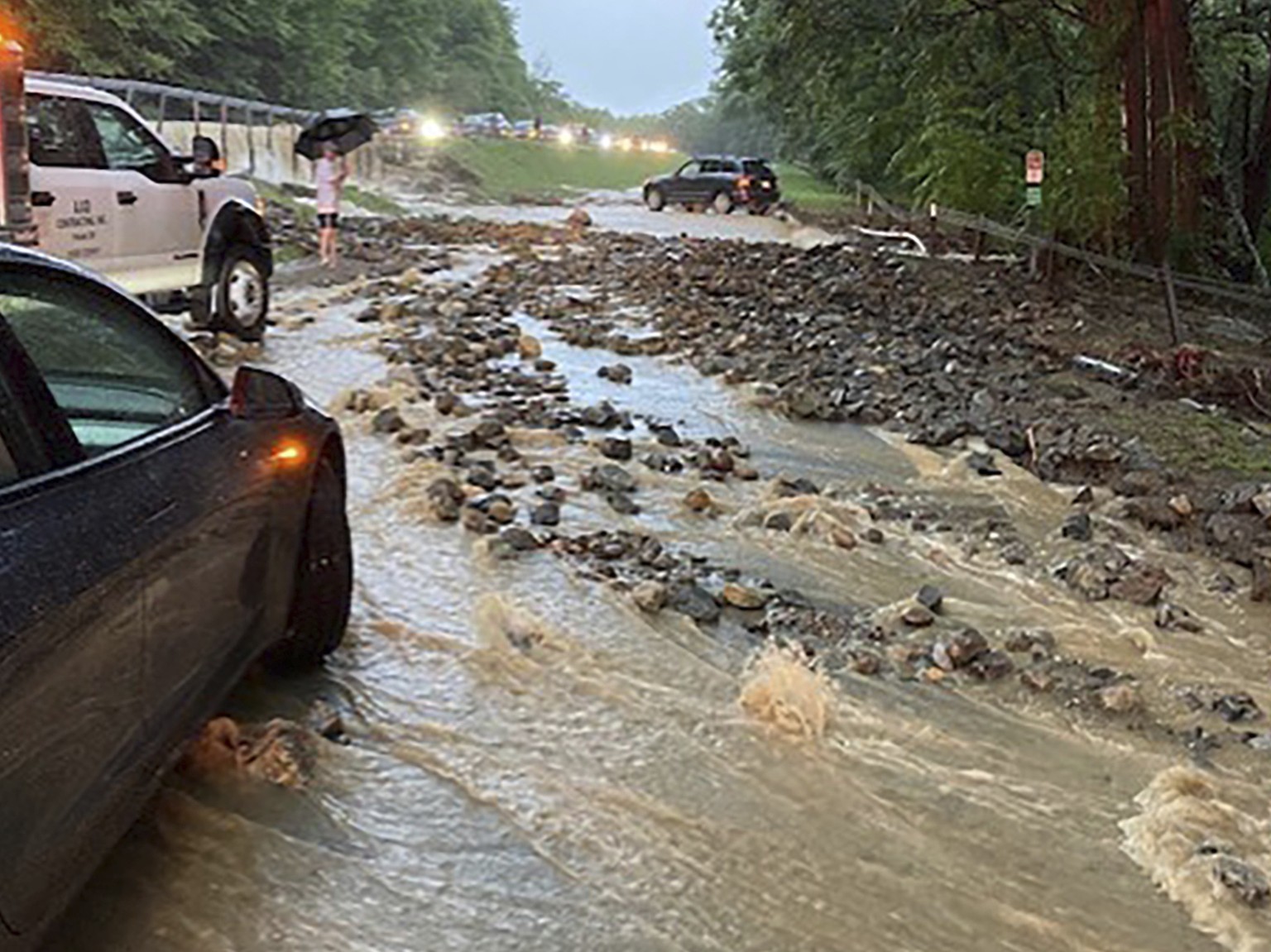 Vehicles come to a standstill near a washed-out and flooded portion of the Palisades Parkway just beyond the traffic circle off the Bear Mountain Bridge, Sunday, July 9, 2023, in Orange County, N.Y. H ...